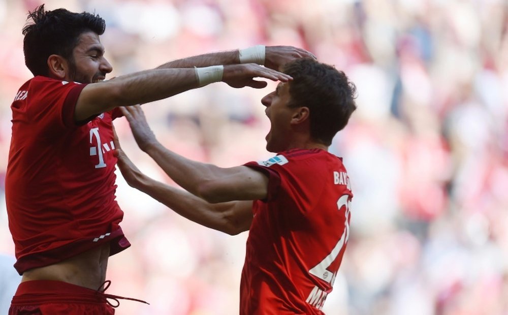 Bayern Munichs striker Thomas Mueller (R) and defender Serdar Tasci celebrate after the first goal during the Bundesliga match of Bayern Munich vs Borussia Moenchengladbach in Munich, Germany on April 30, 2016