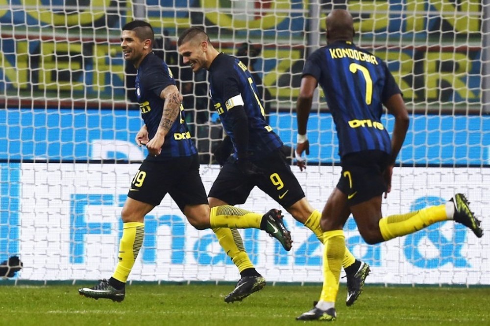 Inter Milans midfielder Ever Banega (L) celebrates with Inter Milans forward Mauro Emanuel Icardi (C) after socring a goal during the Italian Serie A football match between Inter Milan and Lazio on December 21, 2016