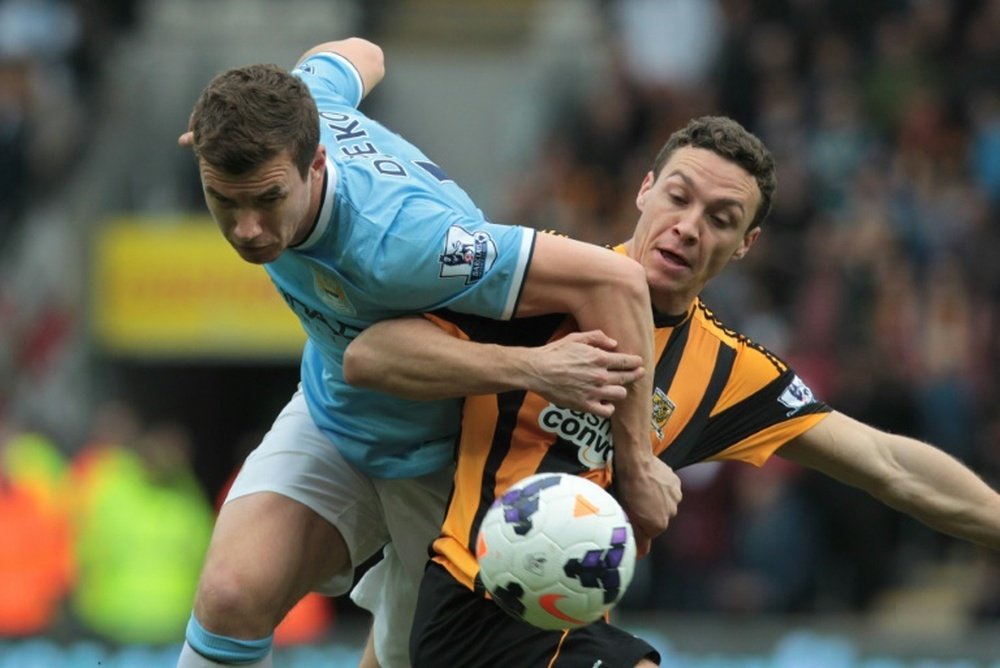 Hull Citys English defender James Chester (right) vies with Manchester Citys Bosnian striker Edin Dzeko during their English Premier League match at the KC Stadium in Hull on March 15, 2014