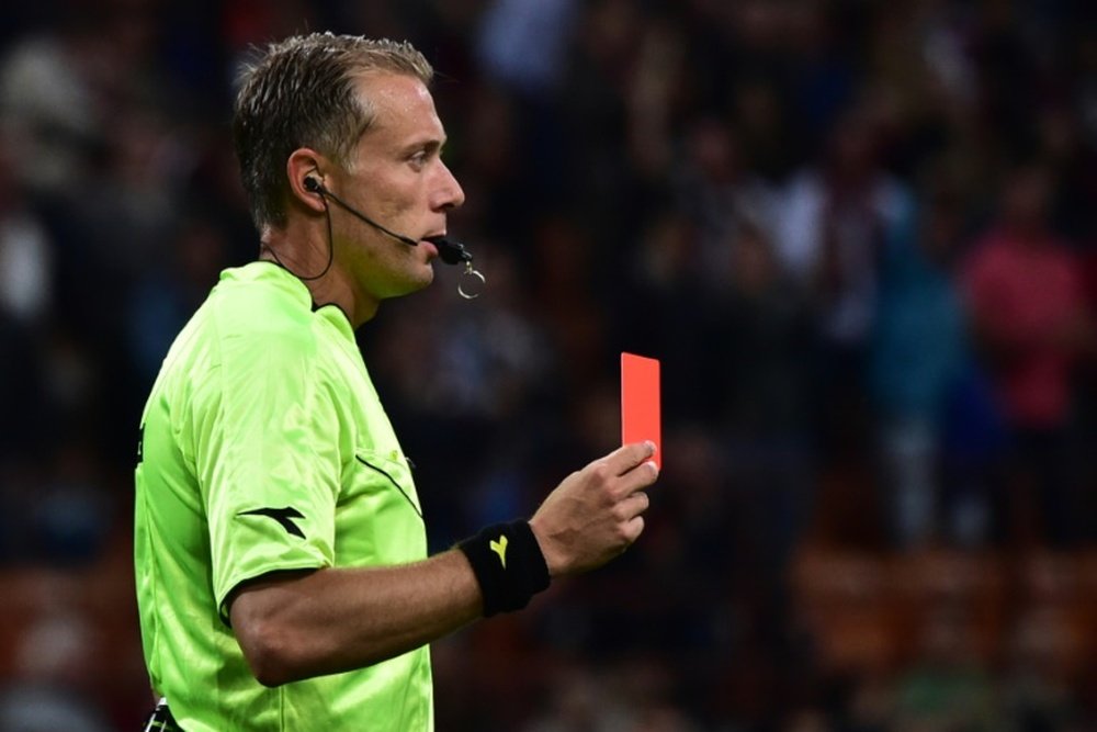 Referee Paolo Valeri issues a red card to Torinos Cristian Molinaro (not pictured) during a Serie A match between AC Milan and Torino at San Siro Stadium in Milan on May 24, 2015