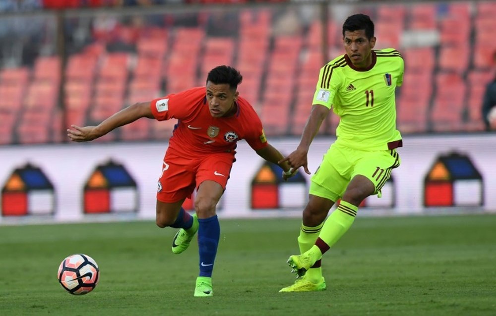 Chiles Alexis Sanchez (L) fights for the ball with Venezuelas Renzo Zambrano
