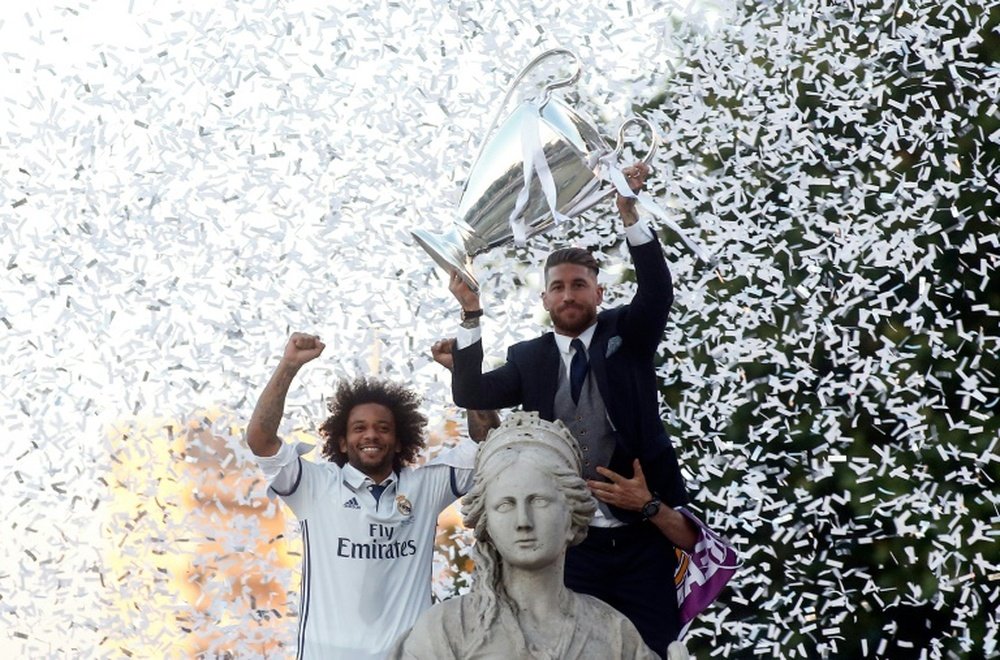Real Madrids defender Sergio Ramos (R) holds up the trophy beside Marcelo. AFP