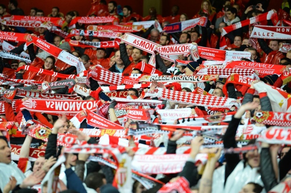 Monaco fans hold up their scarves as they wait for kick off in London on February 25, 2015