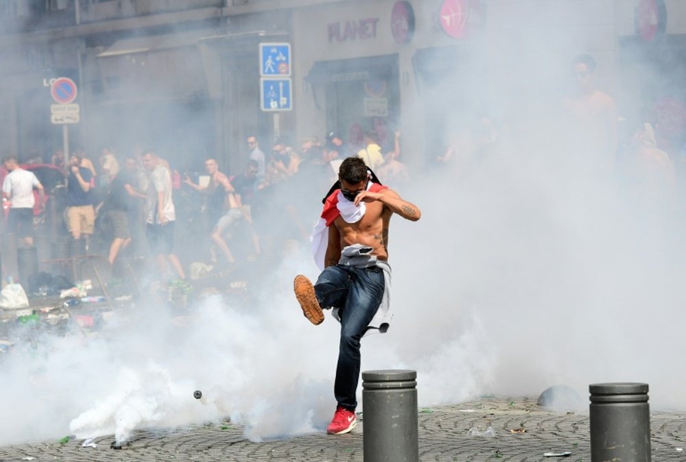 An England fan kicks a tear gas canister from French police in Marseille on June 11, 2016, ahead of the Euro 2016 match between England against Russia