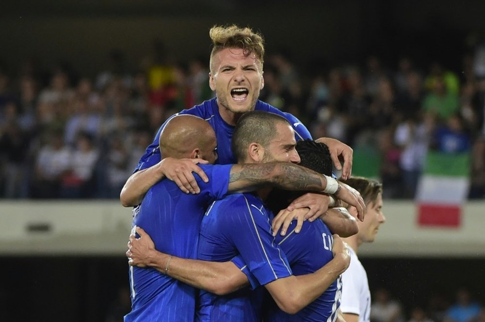 Italys midfieldrer Antonio Candreva (R) celebrates with teammates Ciro Immobile (top) and Leonardo Bonucci (C) after scoring a penalty kick during a friendly football match against Finland on June 6, 2016 in Verona, Italy