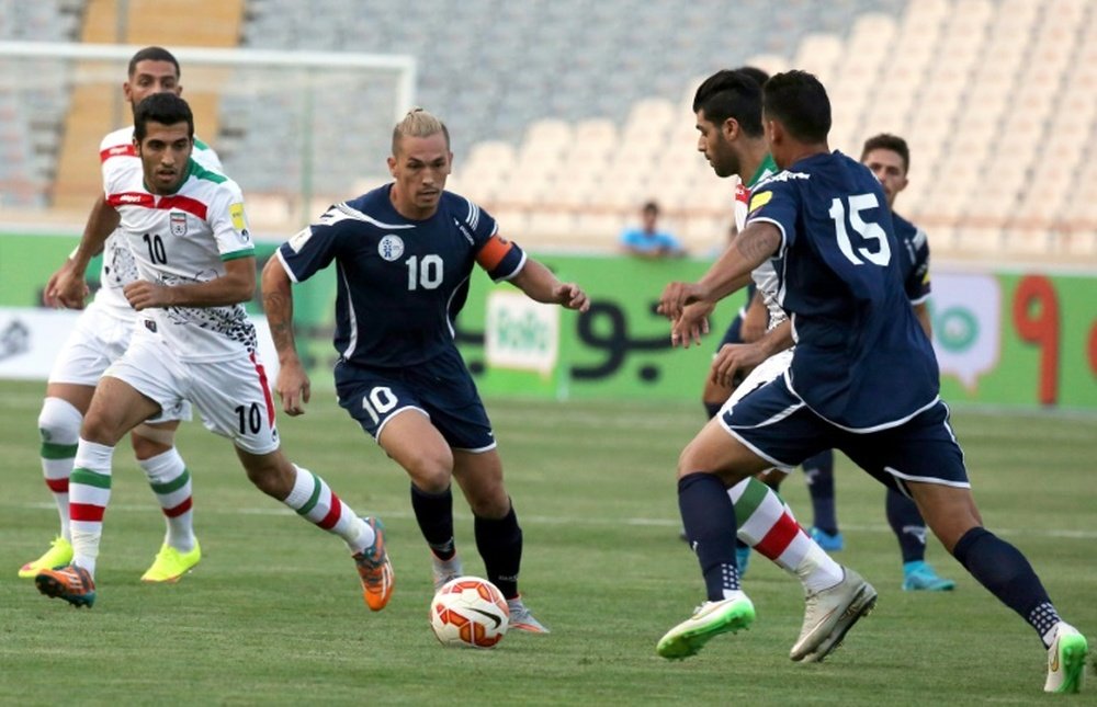 Guams player Jason Cunliffe (C) is challenged by Iranian players during a qualifying match for the 2018 FIFA World Cup at the Azadi stadium in Tehran on September 3, 2015