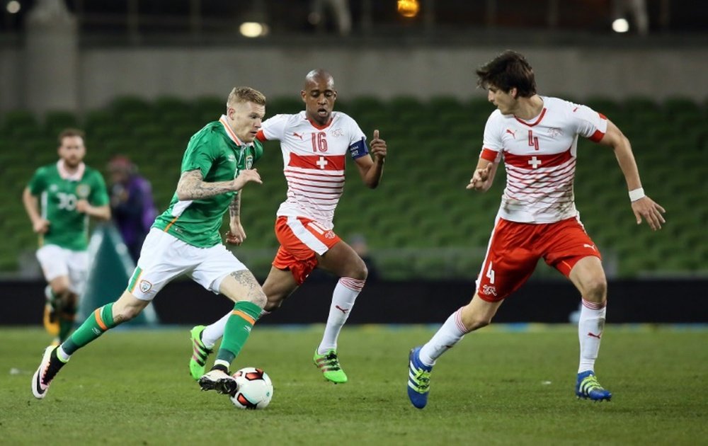 Republic of Irelands midfielder James McClean (L) runs with the ball as Switzerlands midfielder Gelson Fernandes and defender Timm Klose (R) defend during the friendly football match in Dublin on March 25, 2016