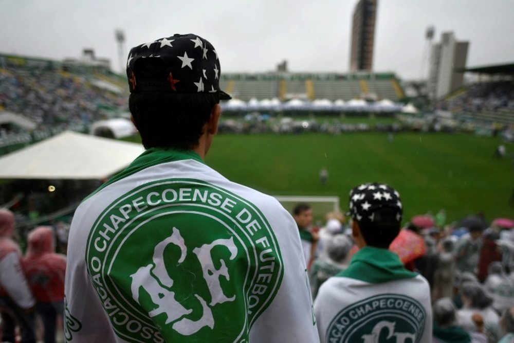 People await for the arrival of the funeral cortege of the players of Brazilian football team Chapecoense Real at the Arena Conda stadium on December 3, 2016
