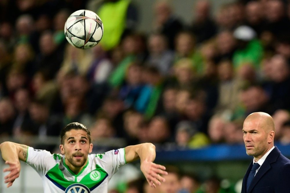 Real Madrids coach Zinedine Zidane (r) looks at Wolfsburgs defender Ricardo Rodriguez during the UEFA Champions League quarter-final, first-leg football match on April 6, 2016 in Wolfsburg, Germany