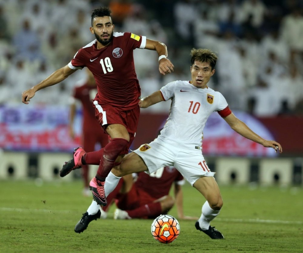 Qatari player Ahmed Yasser (L) defends against Chinese player Zheng Zhi during the AFC qualifying football match for the 2018 FIFA World Cup on October 8, 2015 at Jassim Bin Hamad Stadium in Doha