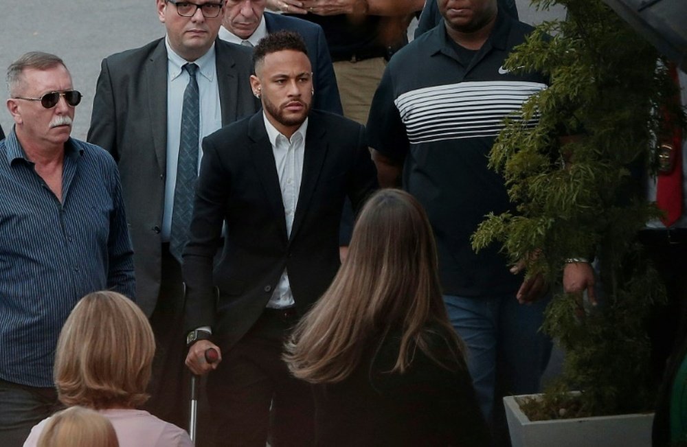 Neymar, arropado al llegar a comisaría. AFP
