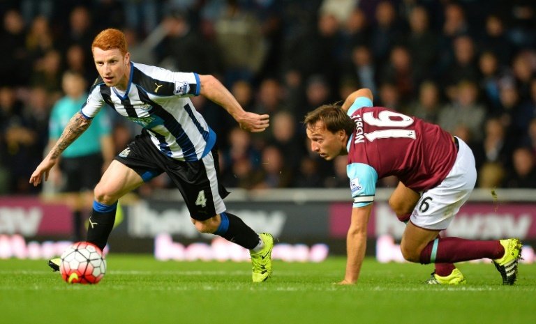 Newcastle midfielder Jack Colback (L) runs with the ball after avoiding a challenge from West Hams Mark Noble during the English Premier League match on September 14, 2015
