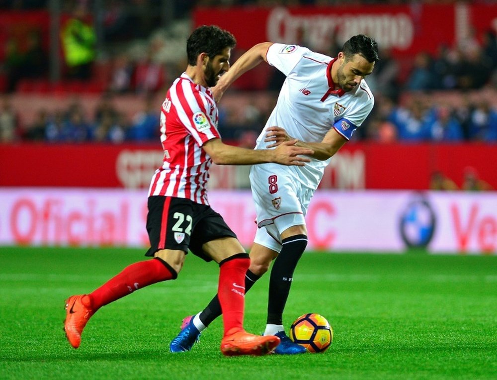 Sevillas midfielder Vicente Iborra (R) vies with Athletics midfielder Raul Garcia