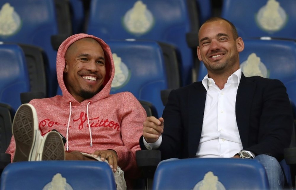 Sneijder (d) podría volver a jugar en el fútbol amateur. AFP