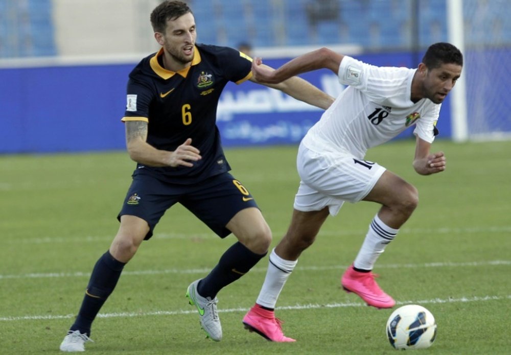 Jordans Hasan Abdel-Fattah (C) dribbles past Australias Matthew Spiranovic during the AFC qualifying football match for the 2018 FIFA World Cup on October 8, 2015 at the Amman International Stadium in the Jordanian capital