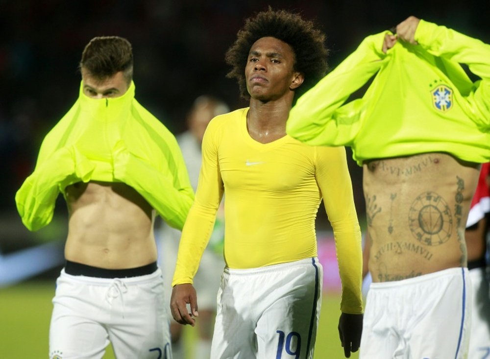 Brazils players Willian (C), Lucas Lima (L), and Dani Alves leave the field at the end of the game on October 8, 2015