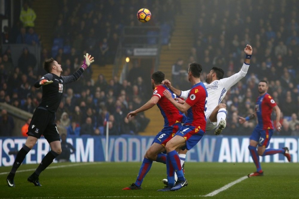 Diego Costa (2R) watches the ball after jumping to head and score against Crystal Palace. AFP