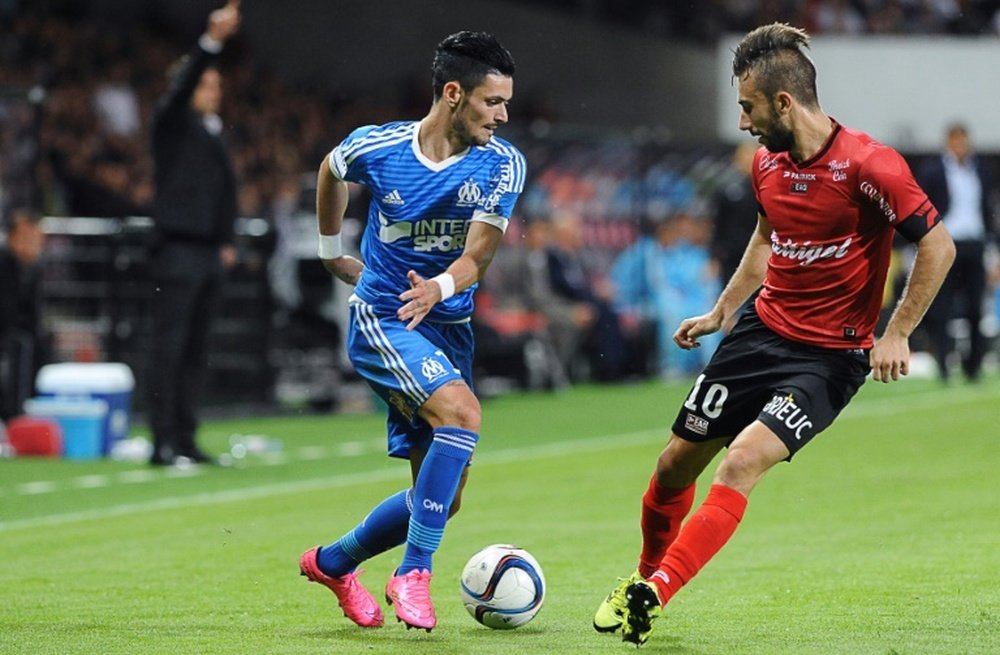 Guingamps French defender Nicolas Benezet (R) vies for the ball with Marseilles French midfielder Remy Cabella during the French L1 football match between Guingamp (EAG) and Marseille (OM) on August 28, 2015 in Guingamp, western France