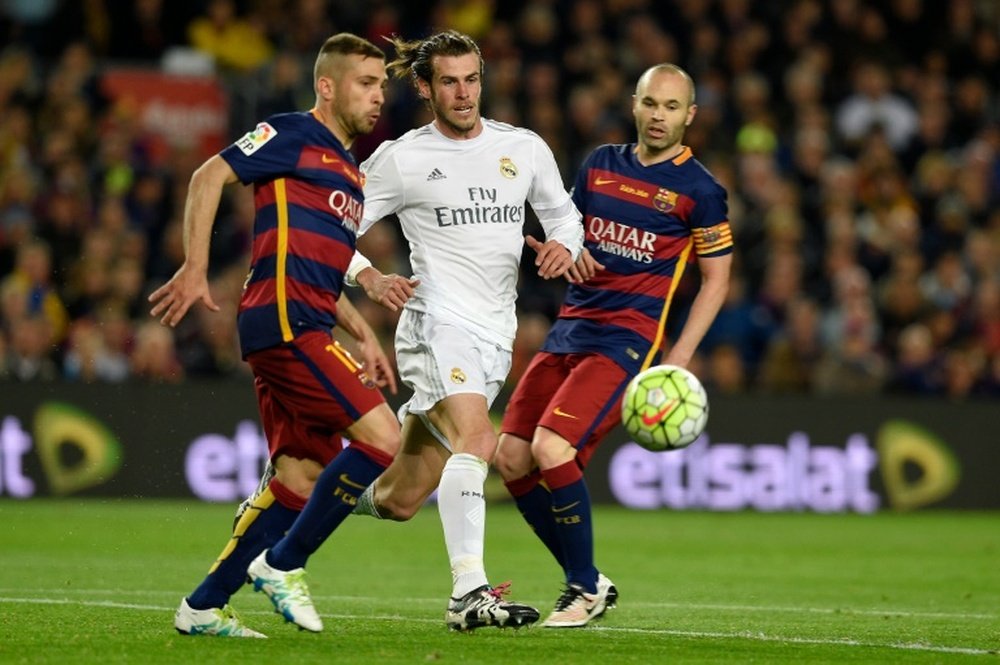 Real Madrid's Welsh forward Gareth Bale (C) vies with Barcelona's midfielder Andres Iniesta (R) and Barcelona's defender Jordi Alba (L) during the Spanish league