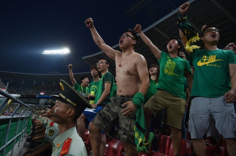 Fans of the Beijing Guoan football team chanting in support during a Chinese Super League match in Beijing
