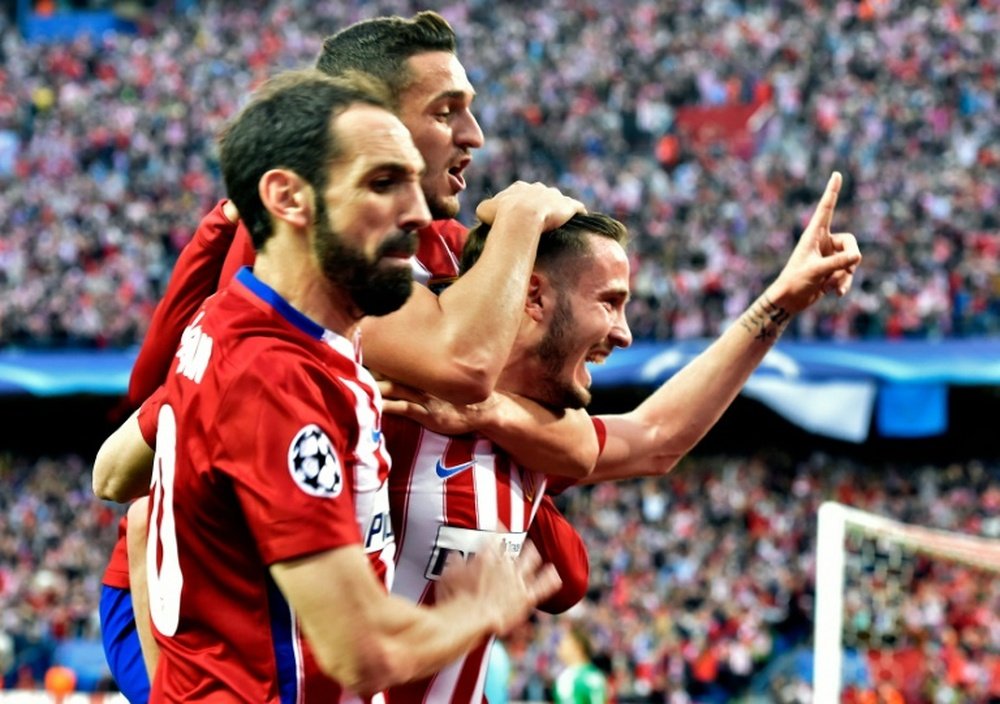 Atletico Madrids midfielder Saul Niguez (R) celebrates with teammates during the UEFA Champions League semifinal first leg football match Club Atletico de Madrid vs Bayern Munich at the Vicente Calderon stadium in Madrid on April 27, 2016