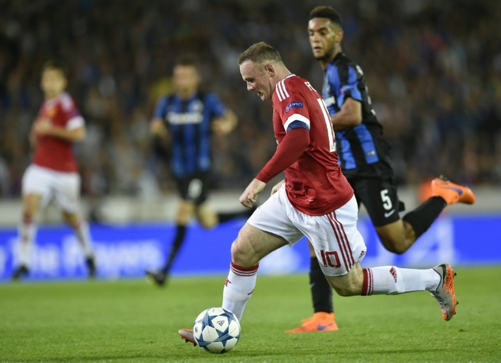 Manchesters Wayne Rooney (R) vies with Club Bruggesâ Jean-Charles Castelletto (C) during the UEFA Champions League playoff football match in Bruges, on August 26, 2015