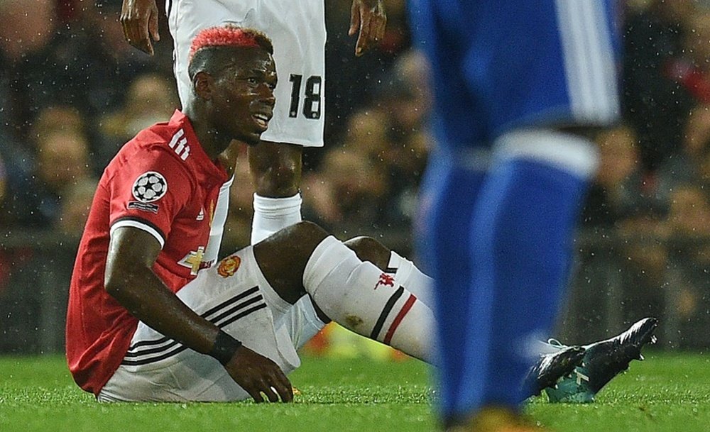 Pogba sits injured during the Champions League match against Basel at Old Trafford. AFP