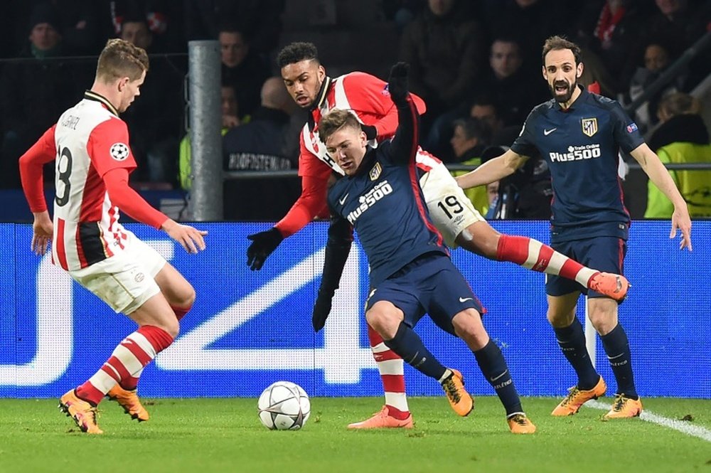Atletico Madrids forward Luciano Vietto (C) fights for the ball against PSV Eindhovens midfielder Marco van Ginkel (L) and forward Jurgen Locadia (Rear) during a UEFA Champions League match on February 24, 2016