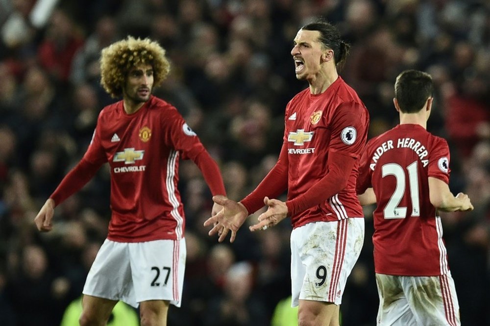 Manchester Uniteds striker Zlatan Ibrahimovic (C) celebrates scoring his teams first goal with Manchester Uniteds midfielder Marouane Fellaini (L) during the English Premier League football match against Liverpool on January 15, 2017