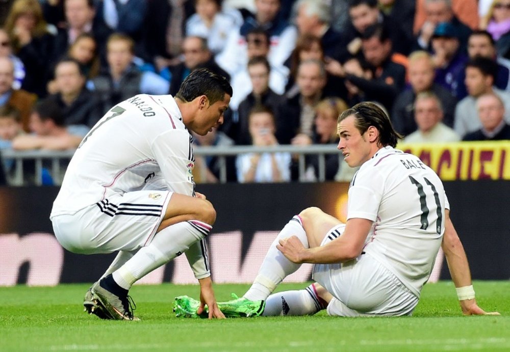 Cristiano y Bale conversan sobre el césped tras caer lesionado este último. AFP