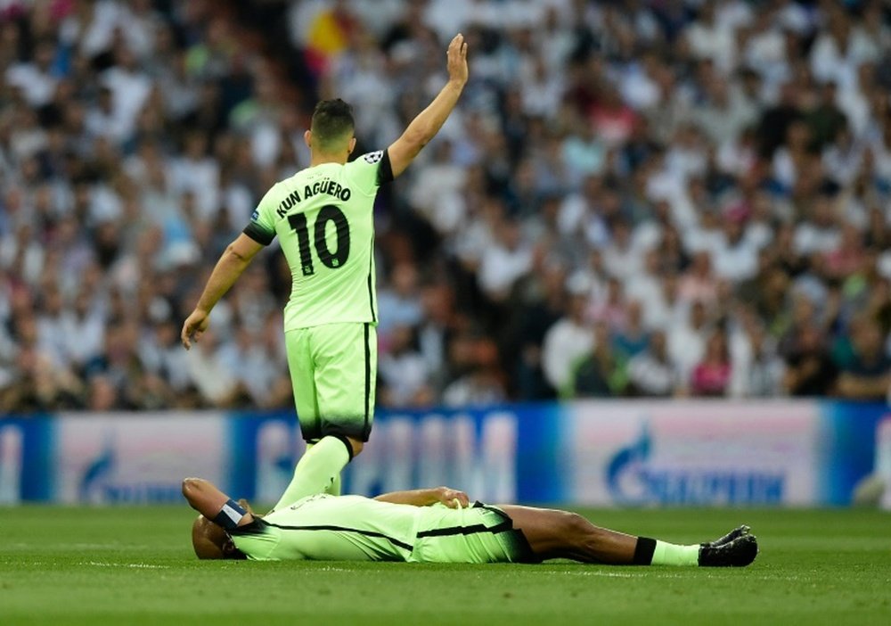 Manchester City defender Vincent Kompany lies on the field as forward Sergio Aguero gestures to the bench during the Champions League semi-final second leg against Real Madrid in Madrid, on May 4, 2016