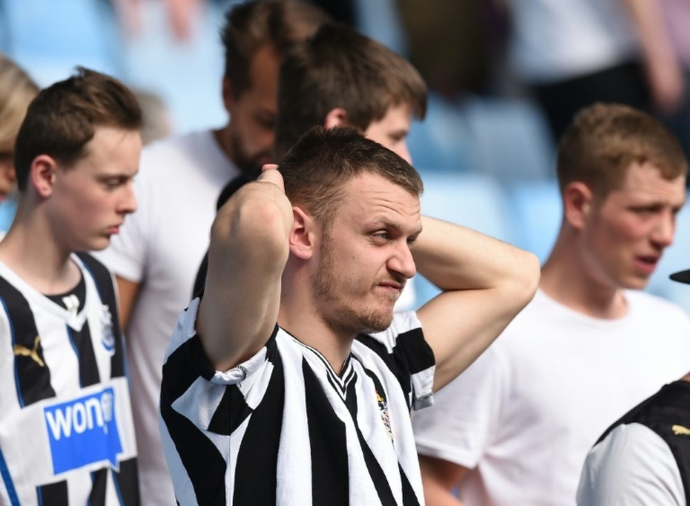Newcastle United supporters react to the news rivals Sunderland have won, consigning them to relegation from the English Premier League