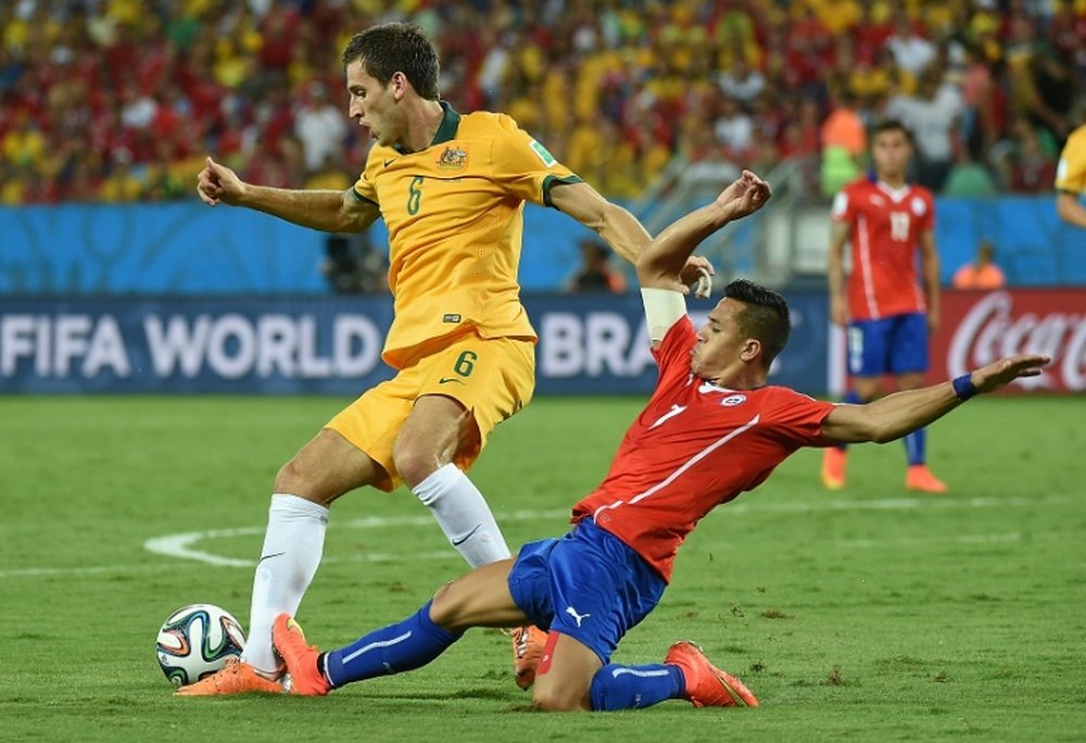 Australias Matthew Spiranovic (L) fights for the ball with Chiles Alexis Sanchez during their 2014 FIFA World Cup group match