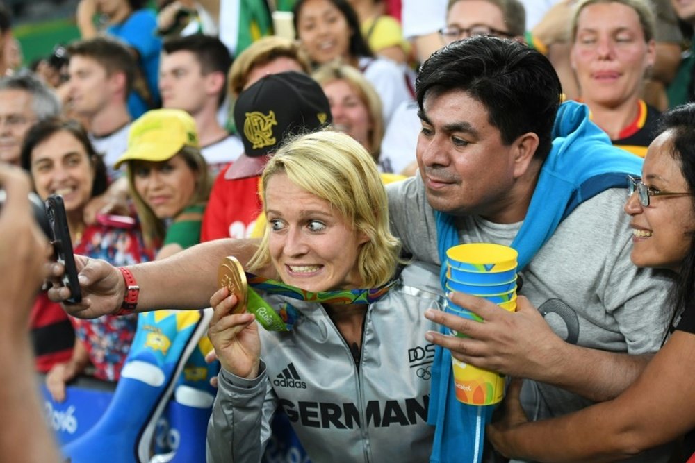 A Germany player holds up her gold medal as she poses for a selfie with a fan. AFP
