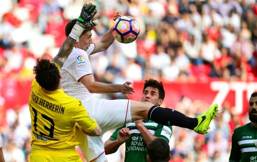 Sevillas Clement Lenglet (C) jumps for the ball with Leganes Iago Herrerin