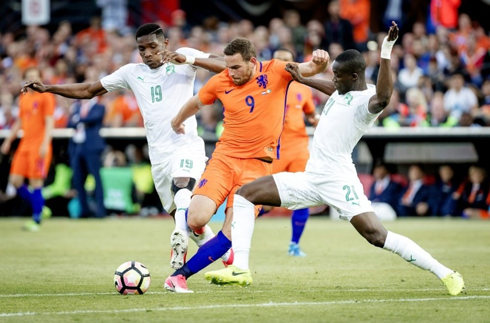 Netherlands Vincent Janssen (C) clashes with Simon Deli. AFP