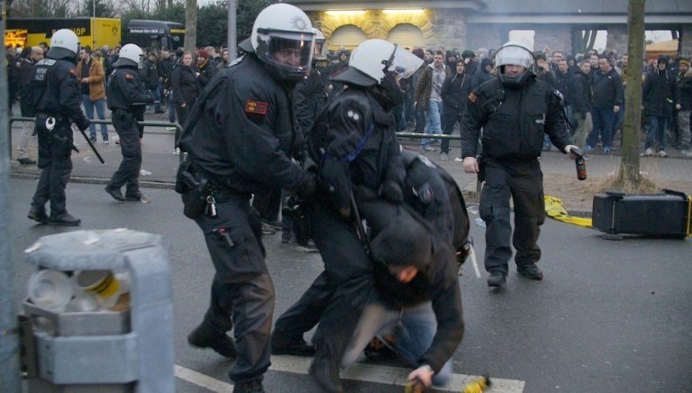 Police officers arresting a Dortmund fan. AFP