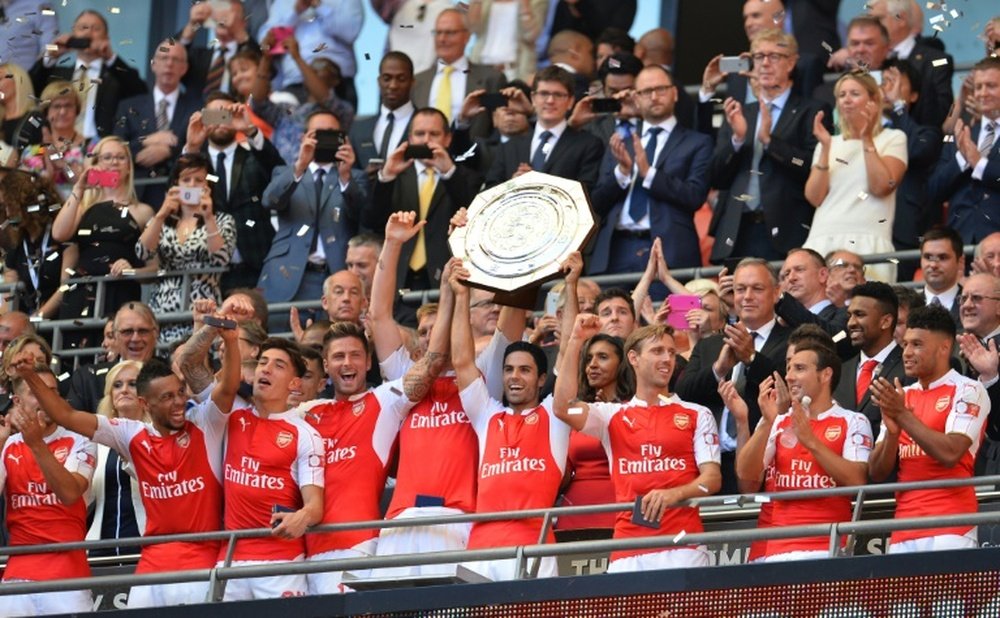 Arsenals midfielder Mikel Arteta (C) lifts the trophy as Arsenal players celebrate after beating Chelsea in the FA Community Shield football match at Wembley Stadium in north London on August 2, 2015