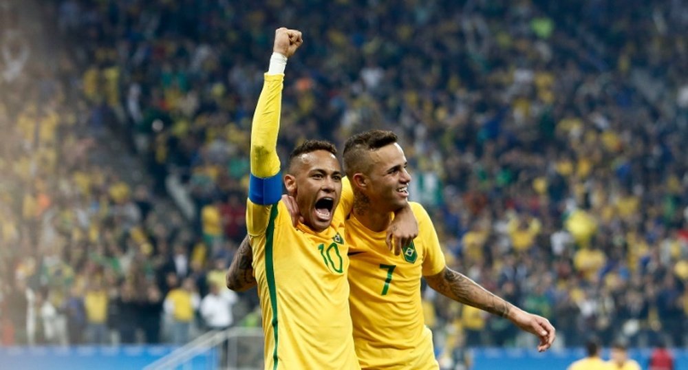 Brazils Luan (R) celebrates with teammate Neymar after scoring a goal against Colombia during their Rio 2016 Olympic Games quarter-final match, at the Corinthians Arena in Sao Paulo, on August 13