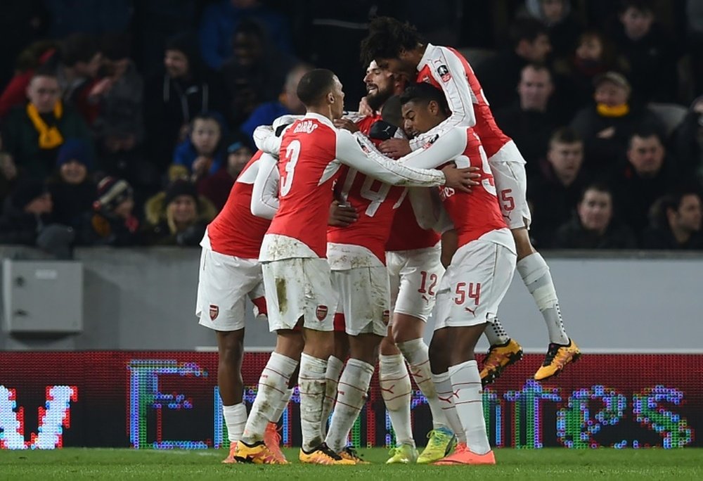 Arsenals midfielder Theo Walcott celebrates with teammates after scoring their third goal during the FA cup fifth round replay football match between Hull City and Arsenal in Kingston upon Hull in north east England on March 8, 2016