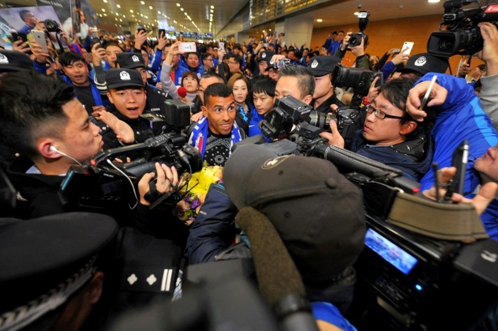 Carlos Tevez makes his way through the arrivals halls at Shanghai Pudong International Airport. AFP