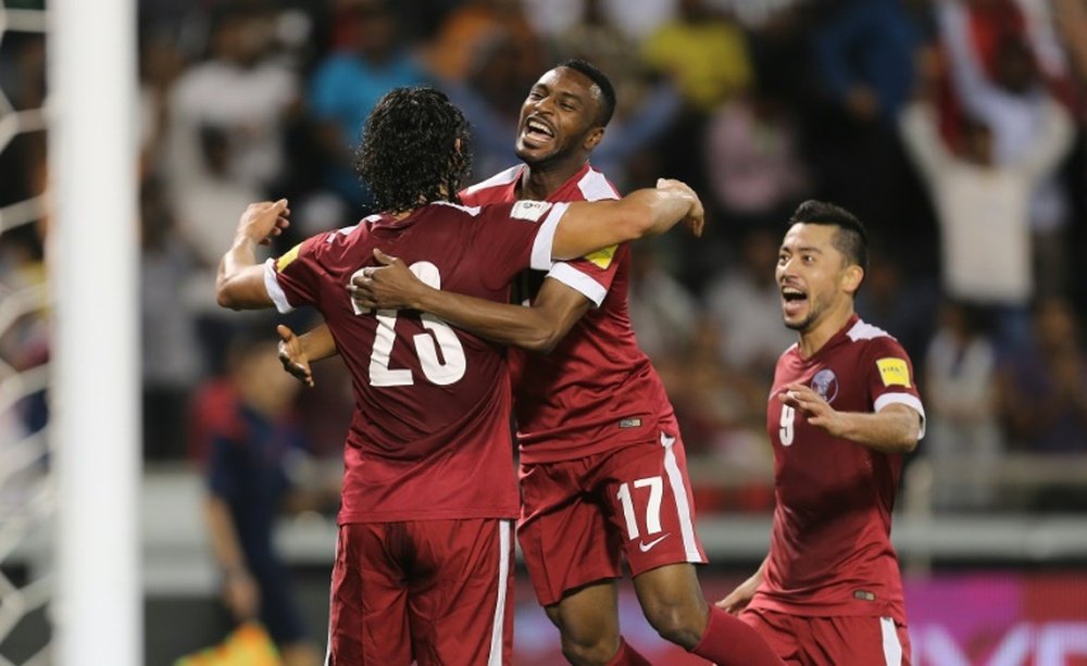 Qatars Sebastian Soria (L) is congratulated by teammate Ismaeel Mohammad (C) after he scored a goal during a 2018 World Cup football qualifying match against Hong Kong in Doha on March 24, 2016