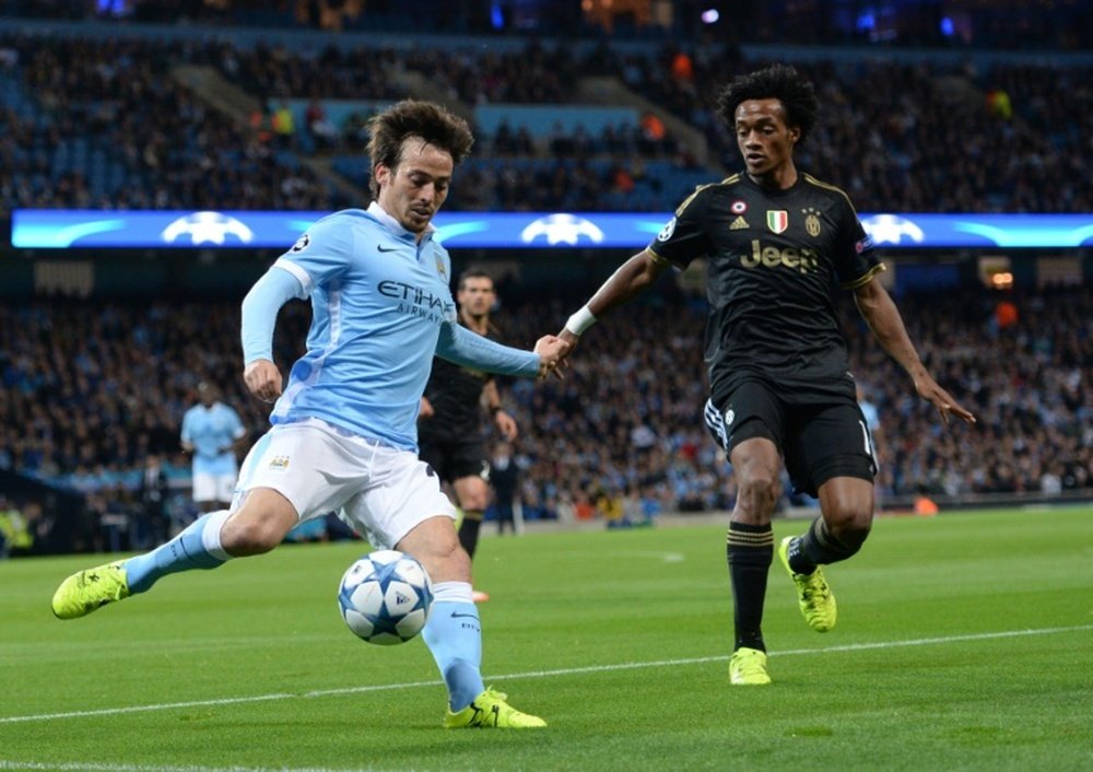 Juventus forward from Coombia Juan Cuadrado (R) tries to tackle Manchester Citys Spanish midfielder David Silva