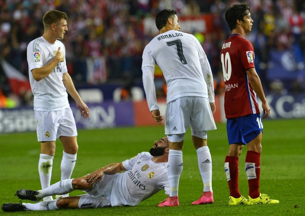 Real Madrids defender Dani Carvajal (down) reacts to an injury on October 4, 2015