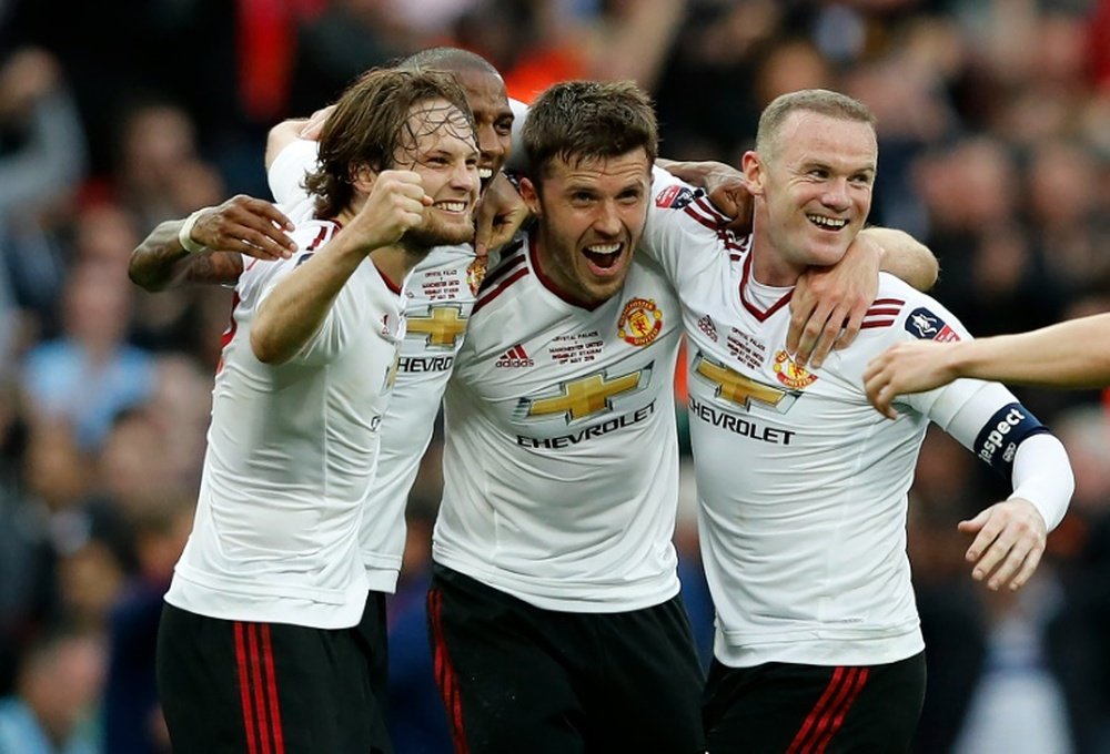 Manchester Uniteds Daley Blind (L), Ashley Young (2nd L), Michael Carrick (2nd R) and Wayne Rooney celebrate on the final whistle after extra time in the English FA Cup final football match at Wembley stadium in London on May 21, 2016