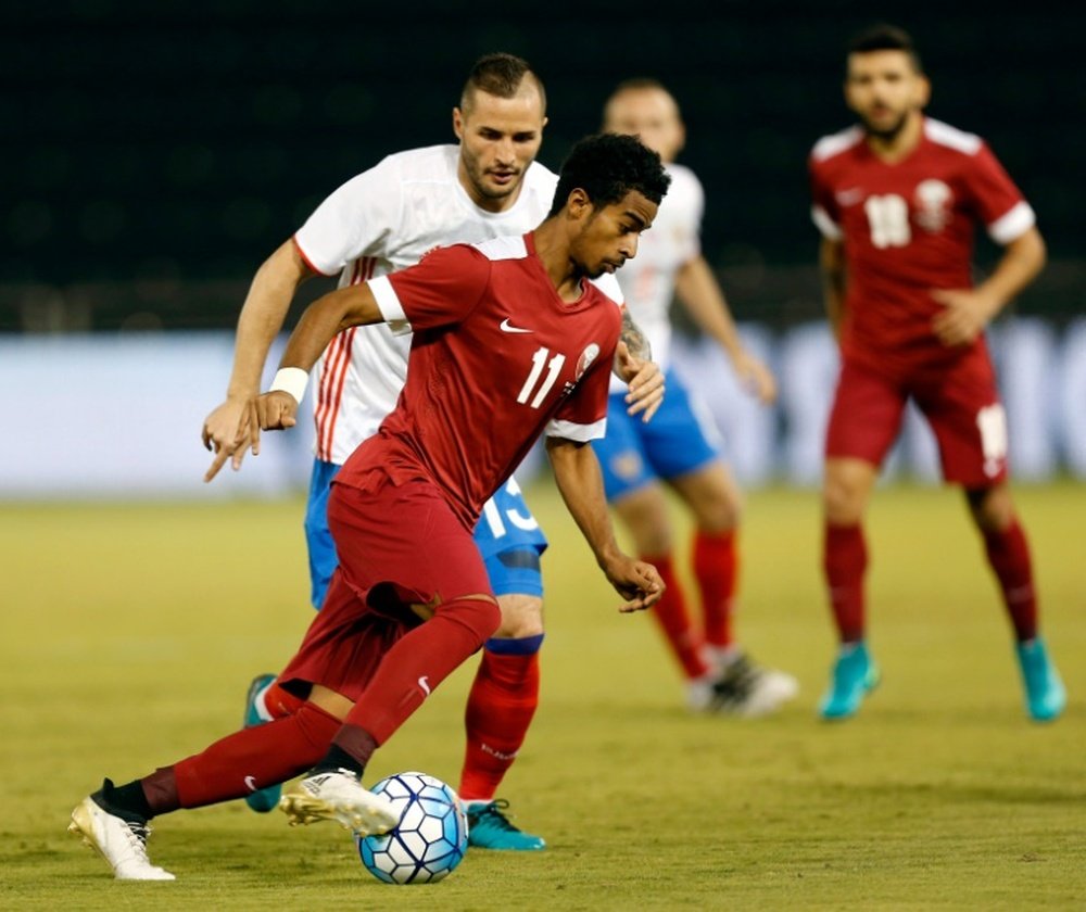 Qatars striker Akram Afif is marked by Russias defender Fedor Koudryashov (L) during the International friendly match between Qatar and Russia at the Jassim Bin Hamad Stadium in Doha on November 10, 2016