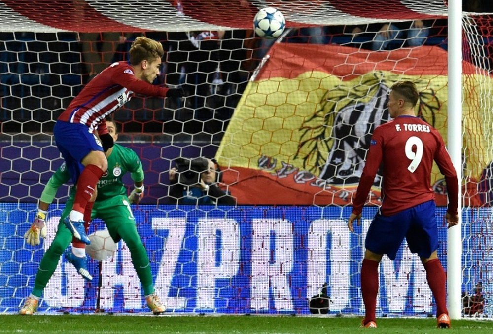 Atletico Madrids forward Antoine Griezmann (L top) heads the ball to score a goal in front of Galatasarays goalkeeper Fernando Muslera (L bottom) during a UEFA Champions League match at the Vicente Calderon stadium in Madrid on November 25, 2015