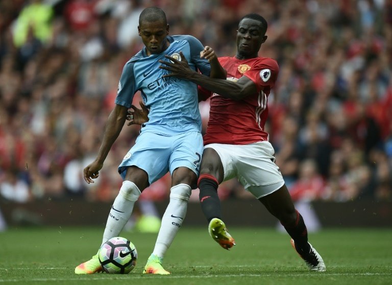 Manchester Citys Fernandinho (L) fights for the ball with Manchester Uniteds Eric Bailly during their English Premier League match, at Old Trafford, on September 10, 2016