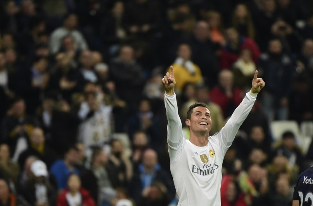 Real Madrids forward Cristiano Ronaldo celebrates after scoring during a UEFA Champions League Group A football match against Malmo at the Santiago Bernabeu stadium in Madrid on December 8, 2015