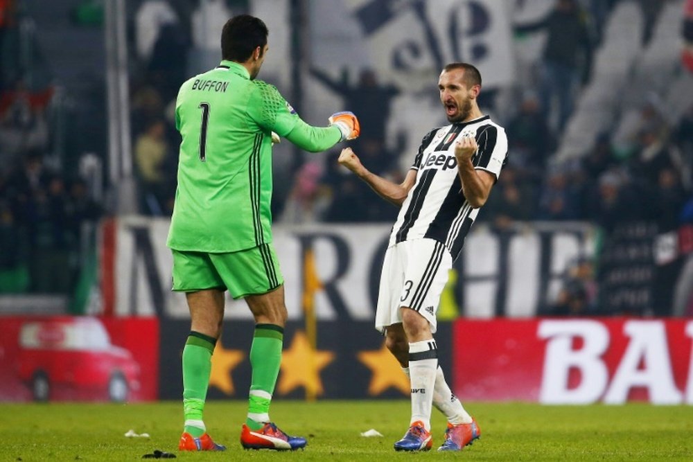 Juventus goalkeeper Gianluigi Buffon (L) celebrates with teammate iorgio Chellini during their game against AS Roma on December 17, 2016 in Turin